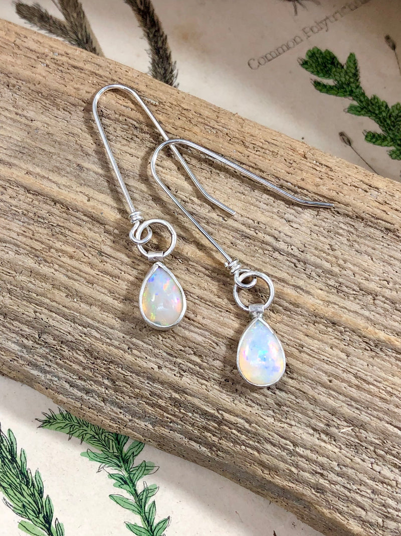 Dainty teardrops of Ethiopian opal are dangled from extra long sterling silver ear wires.  The light plays off these gems so beautifully, it's as though you're gazing upon morning dew.

Product Details:

• 2 pear-shaped Ethiopian opals
• Solid sterling silver
• Sterling silver extra long French ear wires