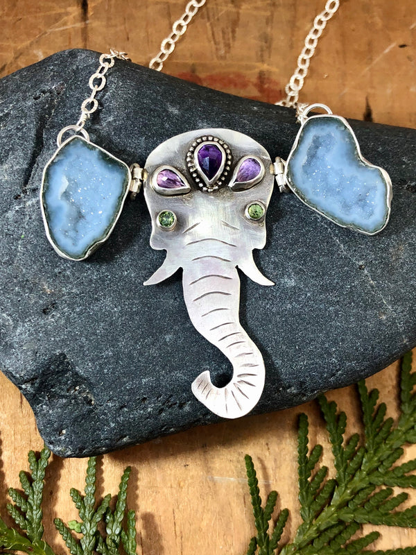 It turns out that the largest living land mammals are also among the most compassionate creatures on earth. Elephants show all kinds of emotions we associate as being human...anger, grief, joy, love...and compassion. A gentle reminder of both the complexity and simplicity of these miracles of Mother Nature. 

This is 'Ellie' she's hand-forged from solid sterling and fine silver with amethyst adornments on her head and green tourmaline eyes. She also has asymmetrical ears (because, let'