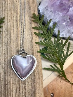 "In the end, only kindness matters." - Jewel

An inspiring cut of Laguna agate with hues of lovely lavender reminds us to open our hearts and let the good in. Let the kindness and compassion in so that we can spread it gently into every facet of our lives. Lovingly handcrafted in fine and sterling silver with a bail of silver balls and a 20 inch chain to hang right over your heart. Finished with a sterling lobster clasp.

Product Details:

• Laguna agate heart cabochon
• Sterling and f