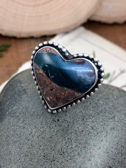 "Be kind, for everyone you meet is fighting a harder battle." - Plato

Glimpse where the sand meets the sea and where the sea meets the clouds in this incredible and rare needles blue agate heart gem. The heart is lovingly encased in fine silver with an accent of solid sterling silver beads around its border. Finished on a sterling silver split shank in size 8 and comfortable enough for everyday wear. Remember who you are, what you mean to others and where your heart feels at home...by
