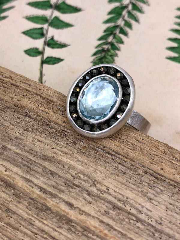 A gem quality aquamarine oval is surrounded by a halo of microfaceted pyrite gems. Set in sterling and fine silver. Size 7

• 1 8x6mm oval aquamarine 
• Micro-faceted pyrite gems 
• Sterling and fine silver• 
• Size 7