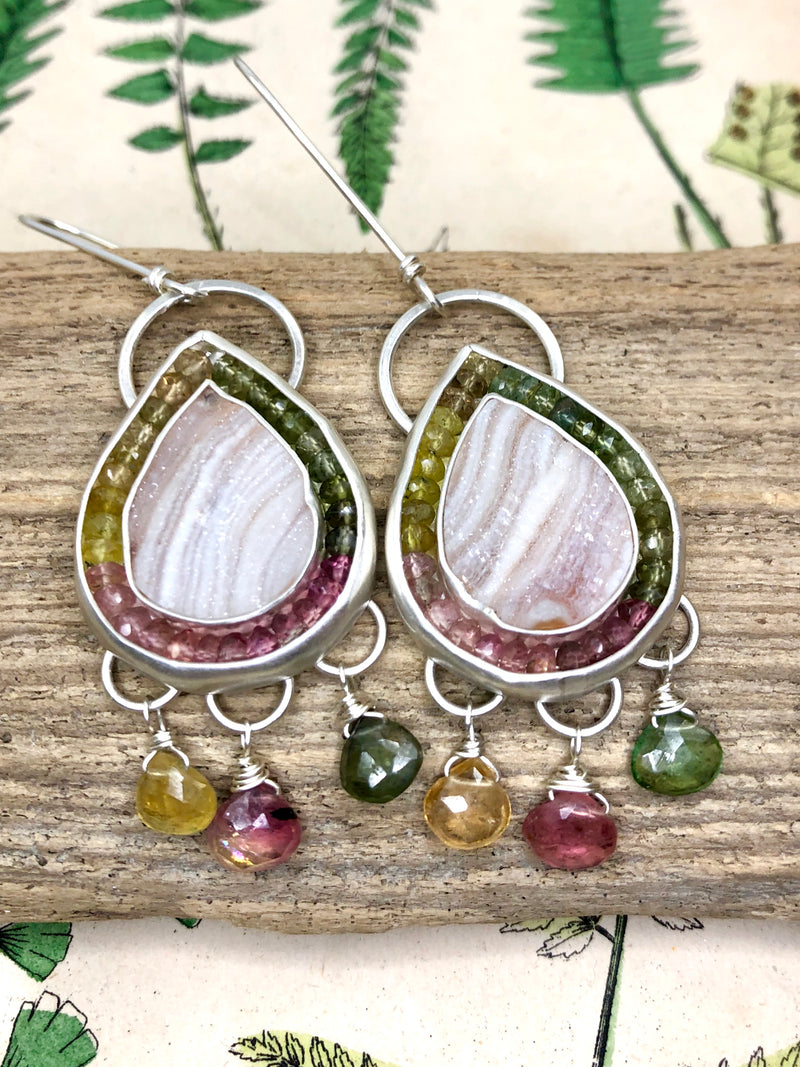Embrace wonder and enchantment. 

A quiet riot of color and texture. Delight in the sparkle and light of desert japer druzy gems. These drop-shaped beauties are artfully surrounded with a halo of multi-colored tourmaline rondelles. Green, pink and yellow amber tourmaline briolettes add movement and complete this sophisticated study in form and color.

•Desert jasper druzy
•Tourmaline rondelles
•Tourmaline briolettes
•Fine and sterling silver
