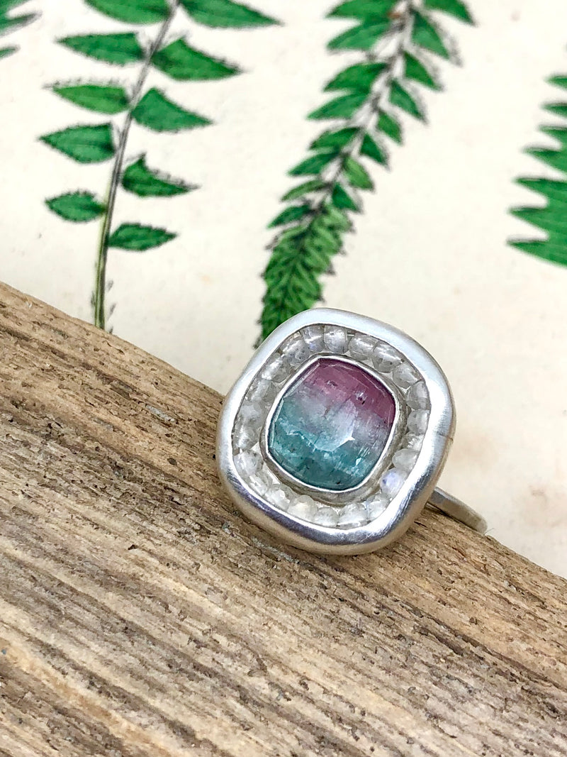 Look for something calming to banish fears and phobias.

The clarity and promise of a rainbow after a clearing storm are captured in this stunning  light-filled composition. A single tri-color tourmaline centered in a halo of rainbow moonstones recalls the fleeting beauty and serenity of refracted sunlight in the rain. Wear this lovely size 6 ring in any weather for a fresh and striking statement. 

• Tri-color rosecut tourmaline
• Rainbow moonstones
• Fine and sterling silver
• Size 6