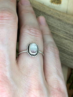 A glorious bi-color, pale pink and green tourmaline is bezel set with a halo of tiny silver beads around it. The tourmaline is rose cut with excellent color and clarity. This ring is dainty and can be stacked or worn alone. Size 6.

• Rose cut bi-color tourmaline 
• Sterling and fine silver 
• Size 6

